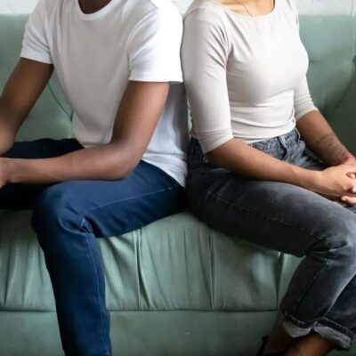 Couple sitting apart on a sofa